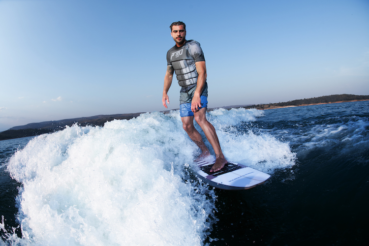 Man surfing in boats wake